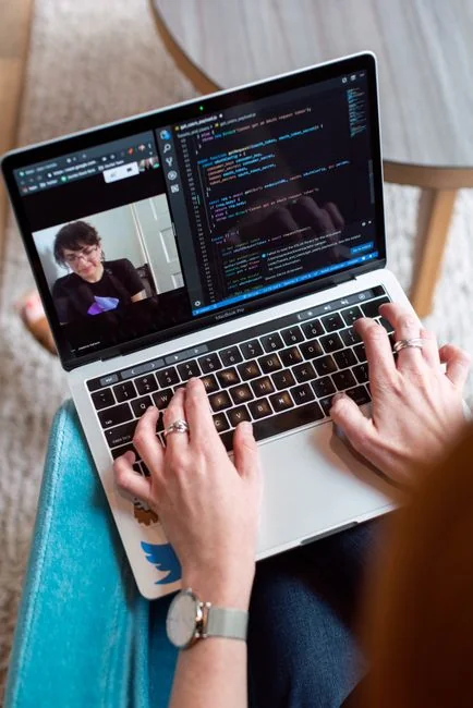 A Lenovo laptop displaying Facebook login beside a lavender plant indoors.